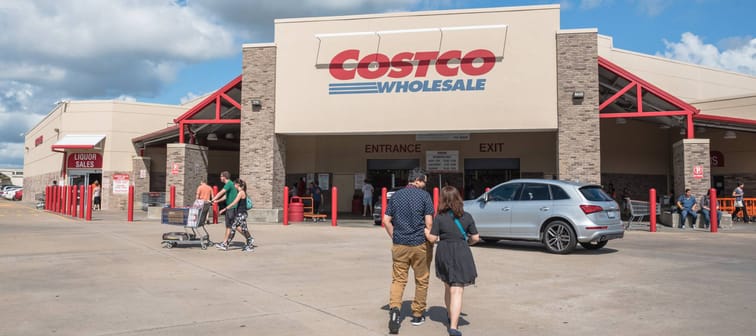 Costco storefront with people walking in and out of front door.