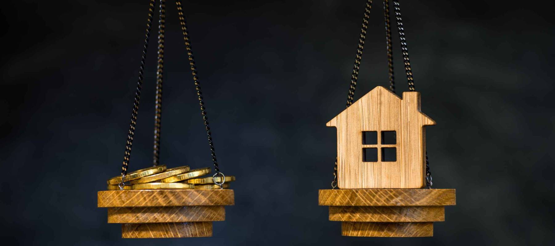 The scales with the coins and the home of the imitation of bamboo. The concept of purchasing housing, credit, and quotes on the real estate market.